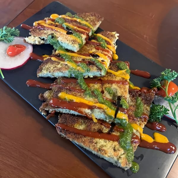 Crispy Nepalese bread slices drizzled with red, yellow, and green sauces, garnished with radish and parsley.