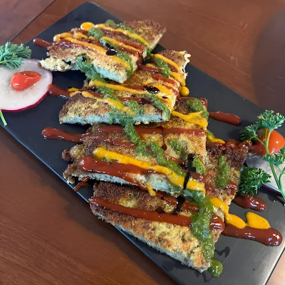 Crispy Nepalese bread slices drizzled with red, yellow, and green sauces, garnished with radish and parsley.